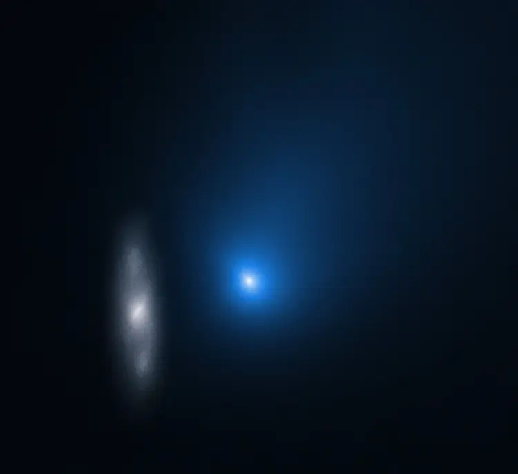 يظهر 2 آي/بوريسوف على أنه نقطة زرقاء مبهمة أمام مجرة حلزونية بعيدة (على اليسار) في هذه الصورة التي التقطها تلسكوب هابل الفضائي في نوفمبر/تشرين الثاني 2019 عندما كان الجرم على بعد نحو 322 مليون كيلومتر عن الأرض. حقوق الصورة: وكالة ناسا، وكالة الفضاء الأوروبية وديفيد جويت (جامعة كاليفورنيا في مدينة لوس أنجلوس)